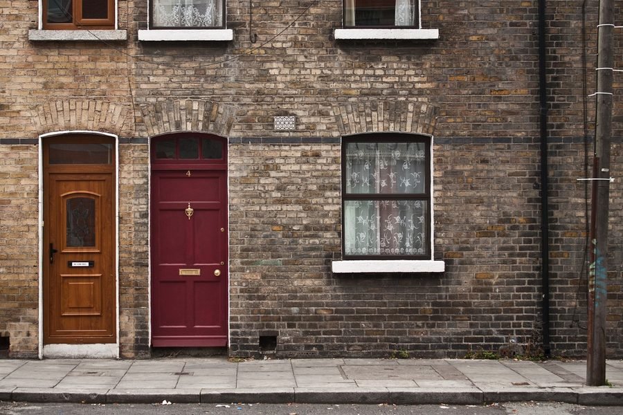 A row of older brick buildings on a quiet street